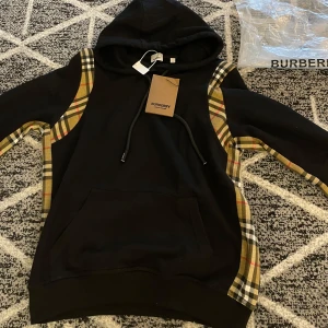 Burberry hoodie svart  - Hej säljer en mycket sällsynt och mycket snygg burberry hoodie, den är aldrig använd då den inte passar mig riktigt. Medföljer Påse + lappar till tröjan inga byten eller skambud.