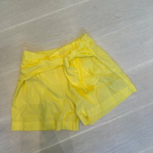 Gula shorts med knytband - Snygga gula Zara viscos shorts med hög midja och brett knytband i midjan. 