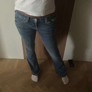 True Religion blå bootcut jeans - Säljer ett par blå jeans från True Religion, storlek 26/32 men de är lite uppsydda. Ordinar pris är 1599💞
