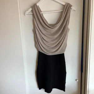 Fest klänning  - Klänning som passar perfekt till fest/mer uppklädda tillfällen/nyår i svart och guld med en snygg ”hängande” överdel. Storlek S men passar även xs. Fint skick⭐️