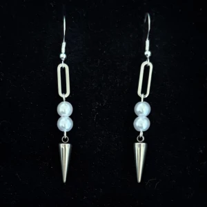 Silvriga örhängen med pärlor och spikes - Handgjorda och unika silverörhängen 🤩 Öronhängerna är nickelfria och silverpläterade i kirurgiskt stål, resterande av örhänget är i rostfritt stål (ej silverpläterat) 💕🙏 5 cm långa. Alla köp görs via ”KÖP NU” knappen.  💐