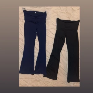 Mörkblå och svart bootcut yogapants - Två supersköna mörkblåa och svarta yogapants med bootcut-ben. Byxorna är i stretchigt material och sitter tajt upptill men släpper ut vid vaden för en snygg siluett. Perfekta för chill eller när du vill vara bekväm men ändå se trendig ut. Byxorna är också korta i medellängden och känns därför som en xxs. Dem mörkblåa har några håll i sig där i fotänden, annars är de i mycket bra skick. 