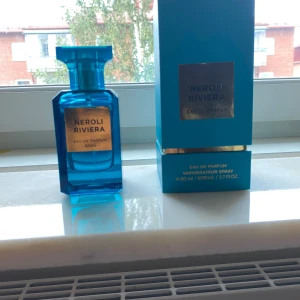 Neroli Riviera Eau de Parfum 80ml - Fräsch parfym i en stilren, blå glasflaska med guldlabel. Flaskan rymmer 80 ml och kommer med matchande blå kartong med gulddetaljer. Doften är Eau de Parfum och flaskan har en modern, kantig design som känns lyxig och trendig. Skriv vid minsta lilla fundering.
