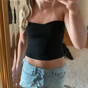 Svart ribbad tubtopp från Lindex XS - Säljer en svart ribbad tubtopp från Lindex i storlek XS. Toppen är bandeau-modell med snygga strukturerade sömmar som ger en cool form. Perfekt att styla med jeans eller kjol för en trendig look. Detaljerna är skit snygga!!