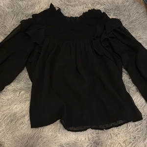 En svart blus ifrån Gina tricot - En svart blus som är långärmad, i storlek 158/164. Den är i nyskick använd en gång💞