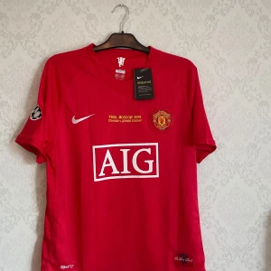 Manchester United Ronaldo 2008 - Manchester Uniteds officiella finaltröja från Champions League-finalen 2008 i Moskva. Röd med gula och vita detaljer, klubbmärke, AIG-logga, Champions League-märke på ärmen och Ronaldo 7 på ryggen. Tillverkad i lätt och ventilerande polyester. Storlek M