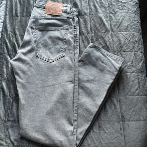 Grå Levi's 502 jeans W32 L34 - Säljer ett par grå Levi's 502 Premium jeans i klassisk straight fit. Jeansen har fem fickor, snyggt läderpatch bak och är tillverkade i mjukt denim. Perfekta för dig som gillar en stilren och avslappnad look. Har varit hos skräddaren och ändrat längden från 36 till 34. 