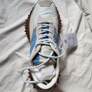 Eytys Fugu sneakers i blått och beige - Säljer ett par feta Eytys sneakers med unik brun sula med nitar, blå och beige ovandel i mocka och textil samt ljusblå snörning. Skorna har cool retrostil och är perfekta för dig som vill sticka ut med din stil. De är Sample så de är ganska unika och sällsynta.