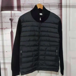 Svart pufferjacka med dragkedja - Svart pufferjacka med quiltad framsida och släta ärmar. Jackan har hög krage, två fickor med dragkedja och hel dragkedja framtill. Perfekt för kyliga dagar och ger en clean, stilren look.