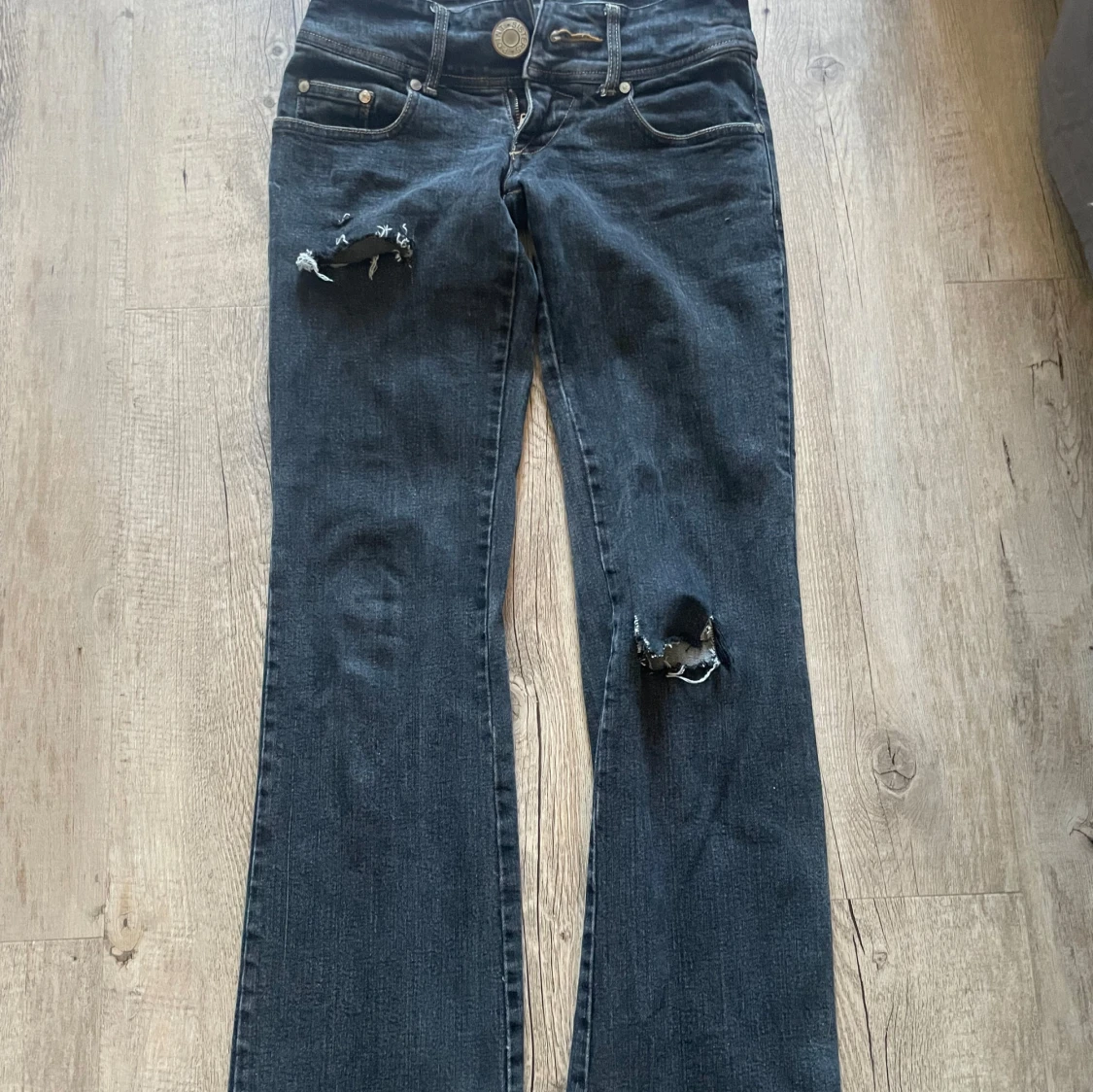 Mörka bootcut jeans med slitningar