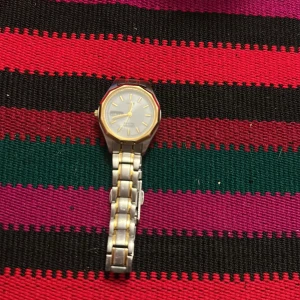 Citizen silver/guld armbandsur - Klassisk Citizen armbandsklocka i silverfärgat stål med gulddetaljer. Rund vit urtavla med dag- och datumvisning, guldfärgade visare och index. Länkat armband i tvåtonad metall ger en stilren och tidlös look.