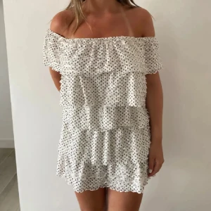 prickig trendig volangklänning  - supersöt trendig kort vit klänning med prickar och volanger. man kan ha den offshoulder eller oneshoulder💕den är från Zara men säljs inte längre💕skriv om ni vill ha mer bilder eller har frågor! 💕