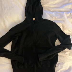 Kashmir tröja från from future  - Svart Kashmir tröja huva och hel dragkedja framtill. Tröjan har långa ärmar och ribbade muddar vid ärmslut och nederkant. Perfekt för en chill och avslappnad stil.