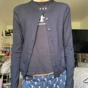 Svart kofta - En klassisk svart kofta med rund hals och knäppning hela vägen framtill. Långärmad och i mjukt, tunt material som passar perfekt till lager-på-lager. Enkel och stilren design som funkar till det mesta😻Så bra att bara slänga på sig snabbt!! Använd några få gånger💋