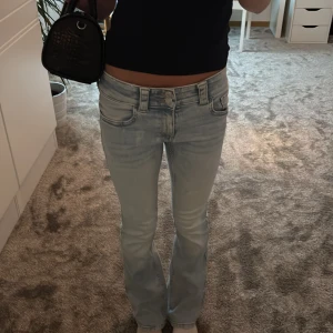 Ljusblå bootcut jeans med fickdetaljer - Säljer ett par ljusblå jeans med bootcut passform och låg midja. Säljer då de är för tighta i midjan/köpte fel storlek 