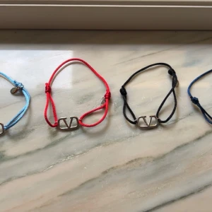 Valentino armband med V-logo - Snygga armband från Valentino med justerbart band i blått, rött eller svart och en silverfärgad V-logo i metall. Priset är per styck och köp sker inte i denna annons ‼️‼️🚨🚨 Kvitto✅✅endast armbandet