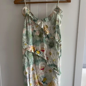Blommig volangklänning med smala axelband - Superfin kort blommig klänning i ljusa pastellfärger med volangdetaljer från HM.  Materialet känns lätt och luftigt.