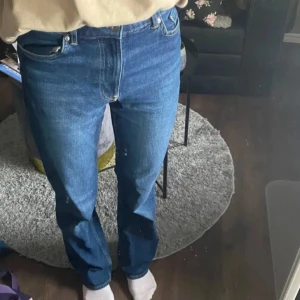 Jeans - Snygga högmidjade blå bootcut jeans med klassisk femficksdesign. De har en knapp och dragkedja framtill. Perfekta för en avslappnad stil. Köpta på H&M