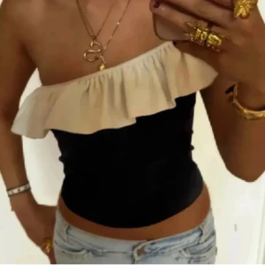 Svart offshoulder topp med volang - Snygg svart offshoulder topp med beige volang💓 i storlek L men passar mig som vanligtvis har S💓 
