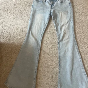True Religion ljusa bootcut jeans - Säljer ett par ljusblå bootcut jeans från True Religion, modell Carrie Low Rise Flare. Jeansen har låg midja, klassiska bakfickor med tydlig broderad logga och är tillverkade i mjukt denim. Jättestretchiga och trendiga!!! Pris kan diskuteras. Använda typ två gånger.