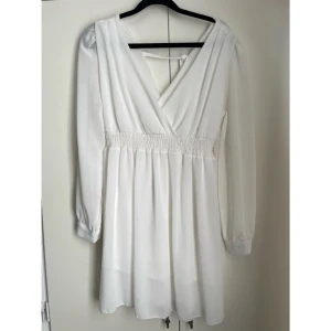 🤍 Vit omlottklänning med långa ärmar – perfekt till sommar & fest! 🤍 - 🤍 Vit omlottklänning med långa ärmar – perfekt till sommar & fest! 🤍  Säljer en vacker, luftig vit klänning med omlottdesign och eleganta, transparenta långärmar i storlek S/M. Klänningen har en smickrande V-ringning, resår i midjan för skön passform, samt ett avtagbart knytband som framhäver midjan på ett fint sätt.   Den är helfodrad (förutom ärmarna) vilket gör att den inte är genomskinlig, samtidigt som ärmarna ger ett lätt och romantiskt intryck. 🌹