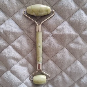 Grön jade roller från Brushworks - Säljer en grön jade roller från Brushworks med två rullar i äkta sten och silverfärgade metalldetaljer. Perfekt för att massera ansiktet och boosta din hudvårdsrutin. Den har en stilren design och känns lyxig i handen.