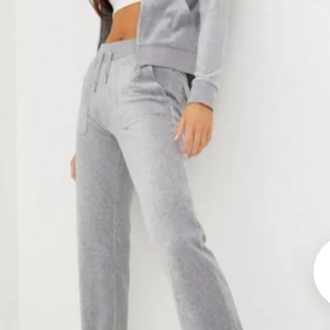 Juicy couture  - Snygga grå mjukisbyxor i mjukt material med bootcut-ben och dragsko i midjan. Perfekta för en chill och avslappnad stil. Byxorna har fickor och en bekväm passform som ger en trendig vibe, finns  permanenta fläckar men inget man tänker på så värst mycket! Säljer för att de inte kommit till användning på ett tag