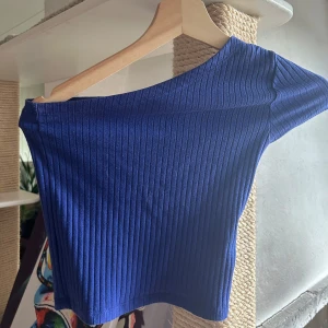Blå topp - Blå topp med en arm ifrån GinaTricot, storlek xs, typ aldrig använd