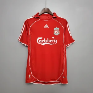 06 LIVERPOOL (RETRO)  - Liverpool FC matchtröja i rött med vita detaljer och klassiska Adidas-ränder på axlarna. Broderat klubbmärke på bröstet och Carlsberg-logga framtill. Tillverkad i lätt och ventilerande polyester, perfekt för fotboll eller supporterliv. Leverans 5-20 dagar. 