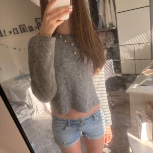 Grå stickad tröja - Supermysig grå stickad tröja med diskret kabelstickat mönster. Tröjan har långa ärmar och en relaxed fit som passar perfekt till jeans eller kjol🩷