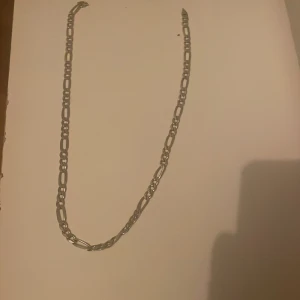 Kedjehalsband i äkta silver 925 - Säljer ett stilrent halsband i äkta silver 925 med klassisk figarokedja. Kedjan har en snygg länkdesign som ger ett coolt och tidlöst intryck. Perfekt för dig som gillar minimalistiska smycken med lite edge. Fast enda problemet är att låset är sönder på halsband men det går att byta låset för 50-100 kr i någon smycke affär.