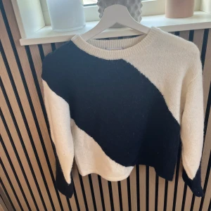 Slut tröja från Gina Young  - Säljer en stickad tröja i svart och vitt med breda diagonala ränder. Tröjan har rund halsringning och långa ärmar. Den är mjuk och har en lite loose passform, perfekt för att hålla sig varm och snygg under kyliga dagar. Unik perfekt till sommaren 