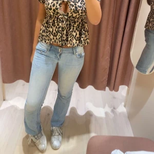 Ljusblå bootcut jeans - Säljer ett par ljusblå jeans med bootcut-modell och låg midja. Jeansen har klassisk femficksdesign och dragkedja med knapp framtill. Perfekta för en avslappnad och trendig look.