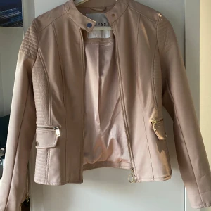Babyrosa läderjacka GUESS - Ljusrosa läderjacka från GUESS, väldigt snygg till sommaren men väljer att sälja då den blivit lite för liten. Knappt använd och i väldigt bra skick 