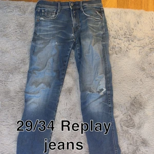 Blå Replay jeans 29/34 - Snygga blå jeans från Replay med slitna detaljer och lätt tvättad look. Klassisk femficksmodell med raka ben och normal passform. Perfekta för en avslappnad och trendig stil.