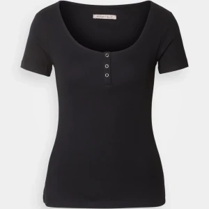 Svart ribbad topp från Anna Field - Svart ribbad topp med rundad urringning och tre dekorativa knappar framtill.
