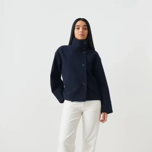 Kort kappa  - Snygg mörkblå kappa i ullmix med rak, boxig passform och hög krage. Jackan har stora knappar framtill och vida ärmar för en chill vibe. Perfekt till jeans eller kostymbyxor för en clean look.