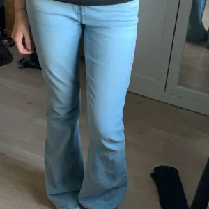 Ljusblå bootcut jeans - Säljer ett par ljusblå jeans med bootcut-modell. Jeansen har klassisk femficksdesign och är tillverkade i mjukt denimtyg. Perfekta för dig som gillar retrovibbar och vill ha en snygg siluett med utsvängda ben.