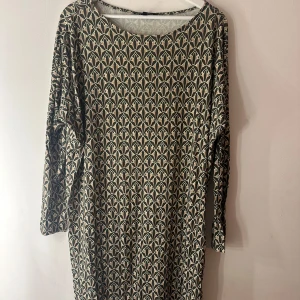 Ilse Jacobsen klänning  - Klänning från Illse Jacobsen med ett unikt mönster i en kombination av beige, svart och olivgröna nyanser. Den har en rund halsringning, vilket gör den bekväm och stilren. Storlek S/M men mer en M.