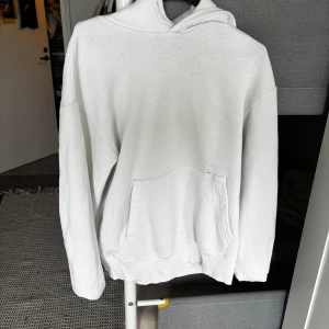 Vit hoodie från Zara med huva - Säljer en stilren vit hoodie från Zara i storlek M. Hoodien har en klassisk känguruficka framtill, ribbade muddar och en skön huva. Perfekt för dig som gillar en enkel och clean look. Materialet är mjukt och bekvämt, passar till många outfits.