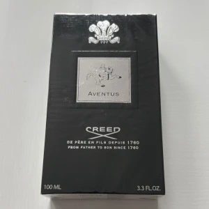 Creed Aventus 100ml parfym - Lyxig parfym Creed Aventus i svart och silver förpackning, 100 ml. Känd för sin ikoniska doft med inslag av frukt, trä och kryddor. Perfekt för dig som vill sticka ut med en exklusiv doft.