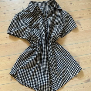 Svartvit rutig skjorta från Isolde - Jättesöt svartvit rutig skjorta från Isolde i klassisk modell med korta ärmar, fickor och knappar framtill. Skjortan är i mycket bra skick! Skriv till mig för frågor😇 