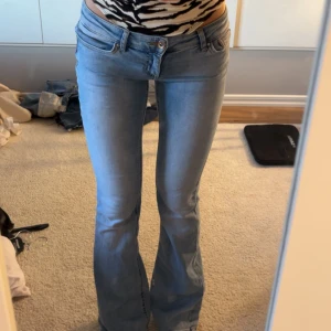 Ljusblå bootcut jeans - Snygga ljusblå jeans med bootcut passform och låg midja. Klassisk femficksmodell med dragkedja och knapp framtill. Perfekta för dig som gillar en retro vibe och vill ha ett par jeans som sitter tajt upptill och släpper ut vid benen. Från only