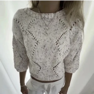 Ljus stickad tröja från Lindex - Superfin ljus stickad tröja från Lindex med coola hålmönster och inslag av rosa, grått och gult. Tröjan har trekvartsärmar. Perfekt till jeans eller kjol för en chill look.