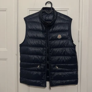 Moncler gui - Size: 3 Pit-to-pit measurement: 53,5cm Length measurement: 57,5cm good Condition! (Dragkedjen behöver bytas - Kostar ungefär 500kr) Color: Navy Comes with: Nothing Retail: 720€