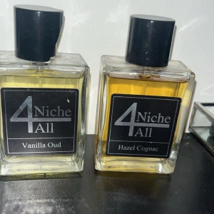 4 Niche All Vanilla Oud & Hazel Cognac - Två stilrena parfymer från 4 Niche All: Vanilla Oud med ljusgul vätska och Hazel Cognac med bärnstensfärgad ton. Båda flaskorna är rektangulära i glas med svarta etiketter och svarta lock. Perfekt för dig som gillar unika doftkombinationer.