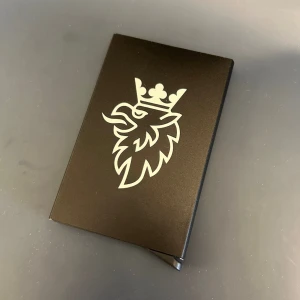 Svart korthållare med gravyr - SAAB - Stilfull och praktisk korthållare med unik gravyr. Korthållaren har en elegant och robust design, vilket gör den till ett utmärkt tillbehör eller som en present till någon speciell.   Egenskaper: Gravyrdesign: Kommer med gravyr enligt bild, vilket ger en unik och exklusiv känsla. Färg: Svart  Leveranstid: 1 - 4 arbetsdagar. Fraktkostnaden avser porto, emballage och hanteringsavgift.  Kolla även in våra andra produkter!