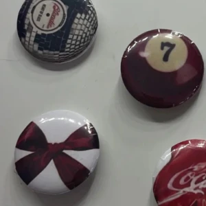 Färgglada retro pins med motiv - Fyra runda pins med coola retro-motiv: en röd rosett på vit bakgrund, en biljardboll nummer 7 och en vinylskiva. Perfekta att sätta på jackan eller väskan för en personlig touch.