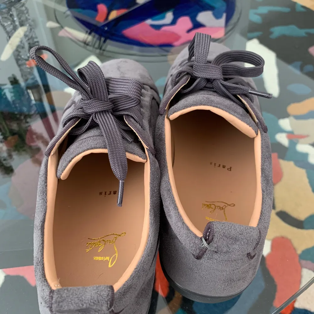 Säljer ett par grå sneakers från Christian Louboutin i mocka med klassisk röd sula och rund tå. Skorna har snörning och diskreta detaljer, perfekt för dig som gillar lyxiga och stilrena sneakers. pris kan diskuteras skriv till mig för mer fråger. Kengät.