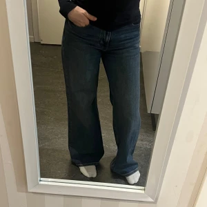 Blåa wide jeans - Säljer ett par klassiska blåa jeans med wide passform och hög midja. Jeansen har en rak siluett och är tillverkade i ett robust denimtyg. Perfekta för dig som gillar en avslappnad och trendig look. Den är dessutom väldigt ny köpt föra året och kom inte till användning ( Fler  bilder kan skickas om det önskas !)